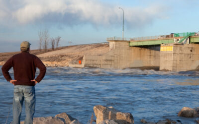 A man looking at a flooded river.