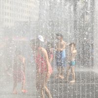 Kids cool off in fountain on a hot summer day.